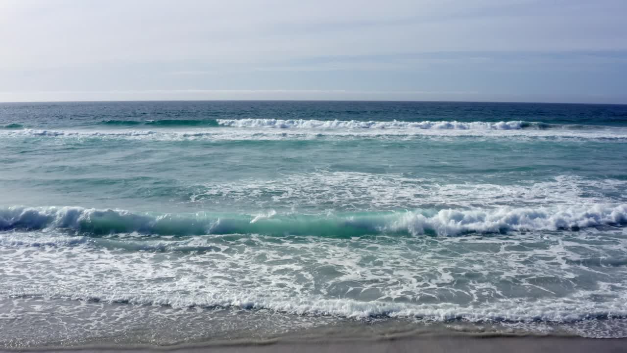 Veduta aerea verso l'orizzonte di onde che si infrangono sulla spiaggia di Carmel-by-the-Sea.