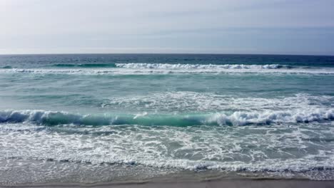 Aerial-Shot-towards-horizon-of-waves-rolling-in-on-Carmel-by-the-Sea-Beach