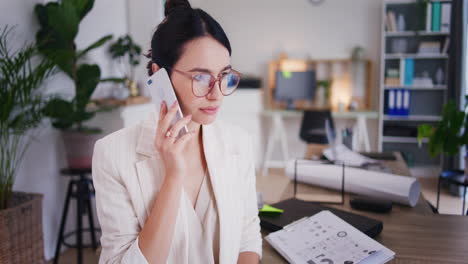 sad woman talks to boss on phone in office