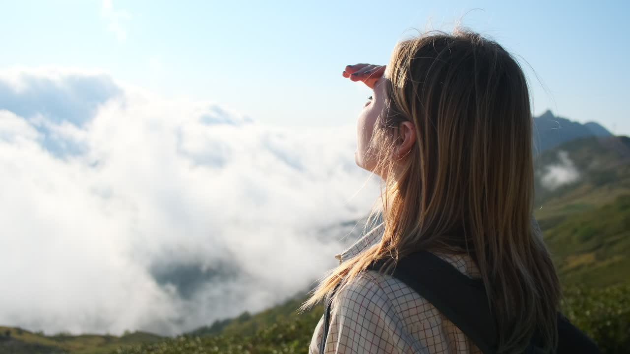 mujer caminando en las montañas con nubes