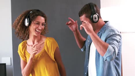 pareja linda escuchando música con auriculares y bailando