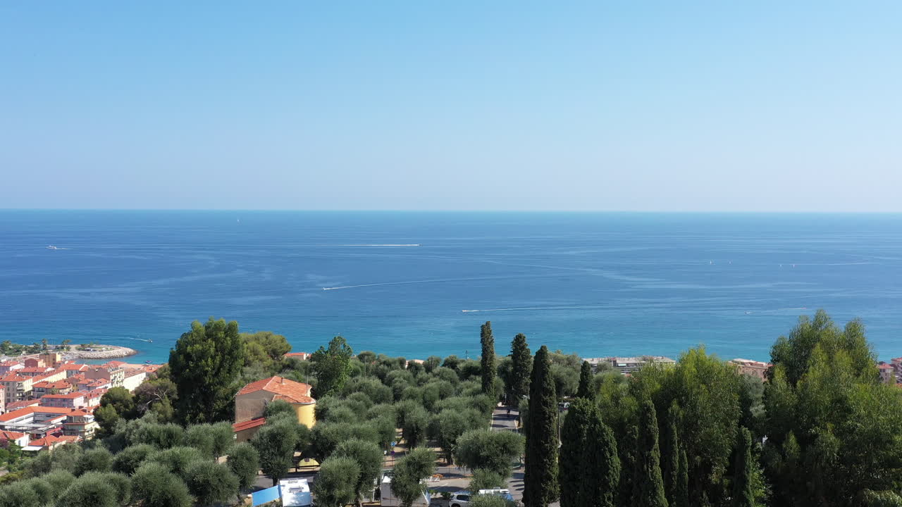 menton, la perla de francia, vista aérea desde una colina con árboles, un día soleado, ciudad costera.