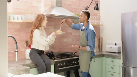 diverse couple cooking breakfast together in cozy kitchen, sharing joyful moments