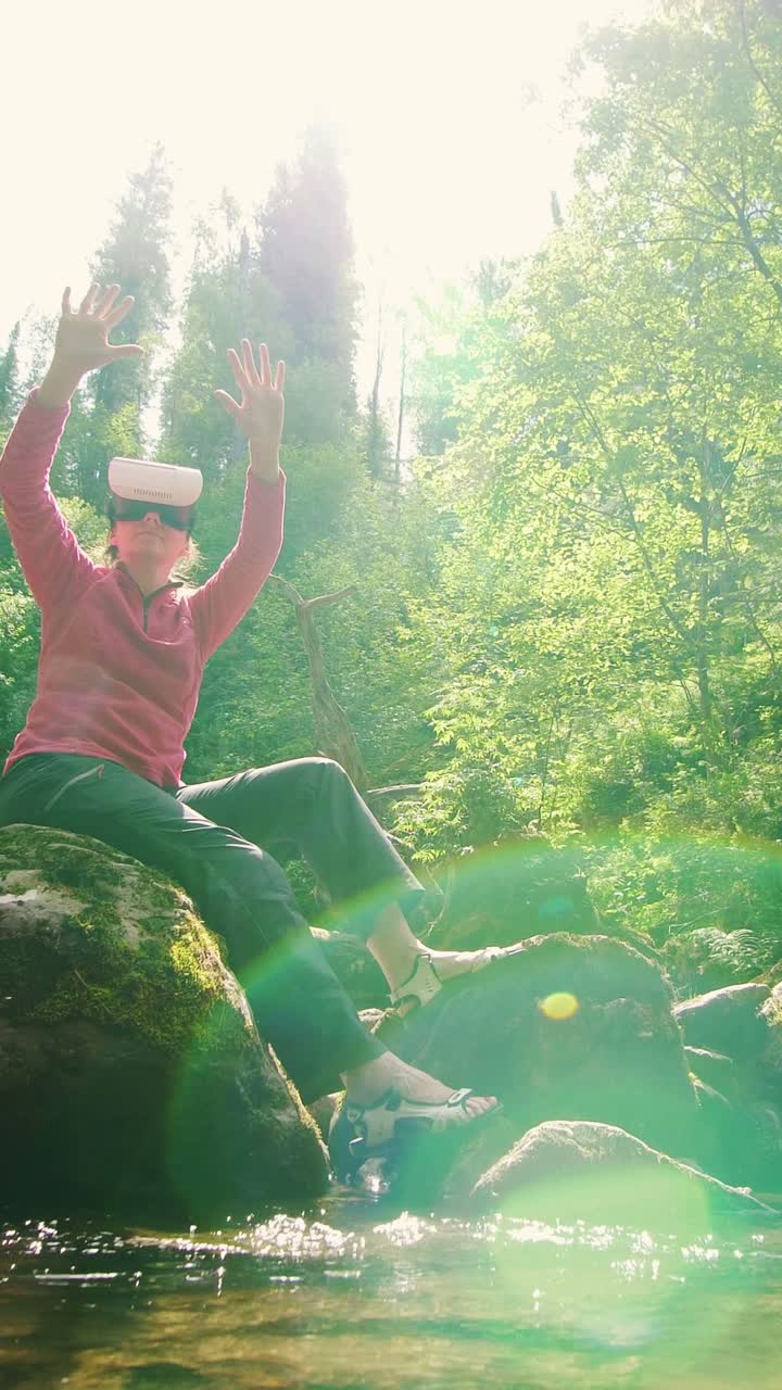 Woman in VR headset enjoying nature by a stream