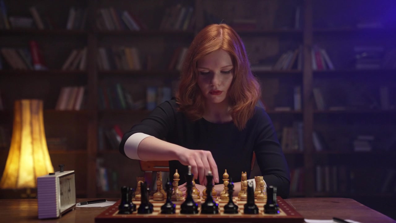 Mulher Ruiva Séria Jogando Xadrez e Gravando Movimentos