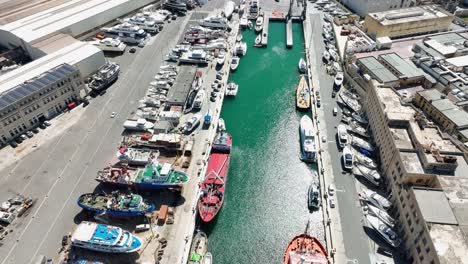 Drone-aerial-shot-pulling-back-over-several-ships-in-a-boat-yard-revealing-a-wide-view-of-the-ship-yard