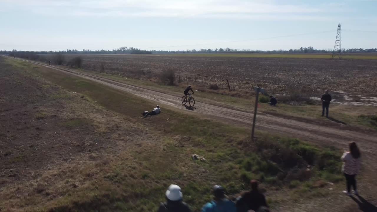 큰 들판을 지나 시골길을 따라 자전거를 탄 남자