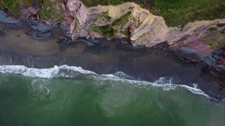 Panoramica aerea di spiaggia e scogliere presso la Copper Coast di Waterford, Irlanda, in un pomeriggio invernale