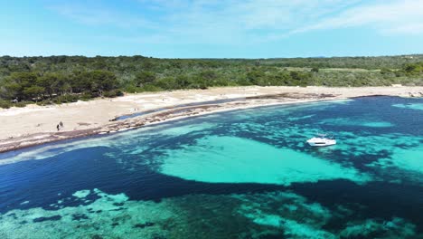 在西班牙的梅諾卡 (menorca) 的桑索拉 (son saura) 處女海灘 (virgin beach) 的浅礁上飛過,