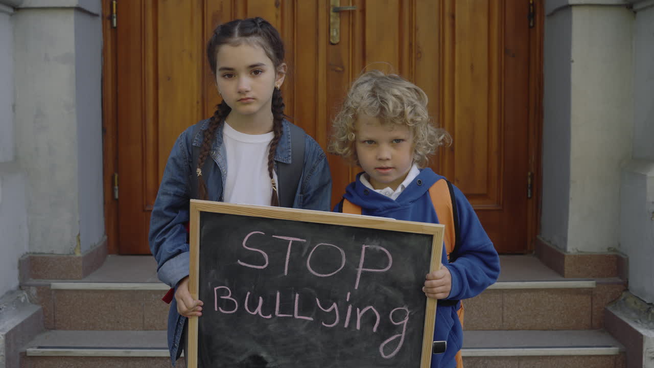Barn som holder et skilt hvor det står "Stopp mobbing."