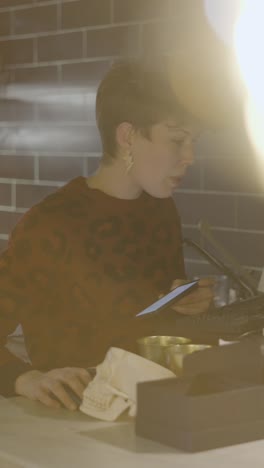 woman working at a counter using a smartphone