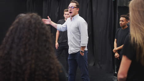 maestro con estudiantes de teatro en la escuela de artes escénicas en la clase de improvisación de estudio