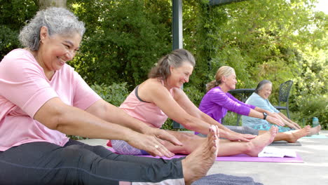 senior biracial woman and diverse group practicing yoga outdoors