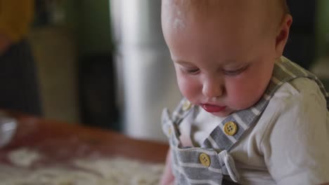 portrait of happy caucasian baby looking at camera in kitchen