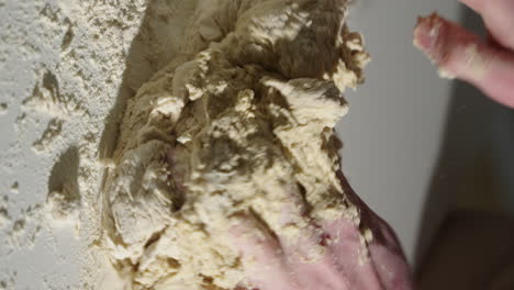 Kneading-dough-by-hand-on-the-kitchen-counter-preparing-homemade-bread