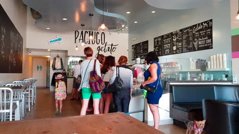 people queuing up at ice cream parlor at hermosa beach, la, california usa on a hot summer day