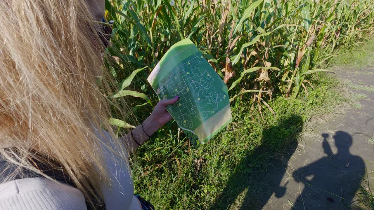 Girl does fun activity of outdoor treasure hunt using map in maze labyrinth