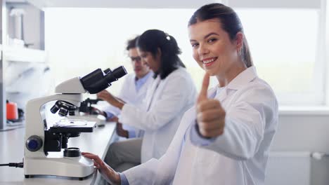 científicas con microscopios trabajando en el laboratorio. investigación científica, trabajo y concepto de personas científicas femeninas internacionales con microscopios trabajando en el laboratorio