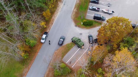 a police intervention with vehicles in a wooded area, day, aerial view