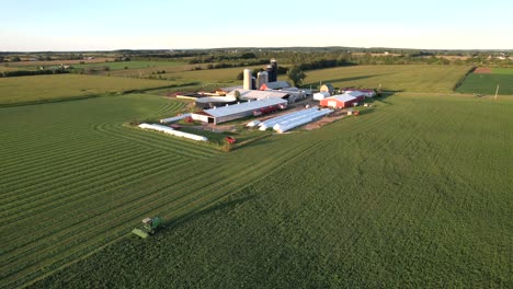 In-Door-County,-WI,-a-farmer-on-a-John-Deere-tractor,-cuts-his-alfalfa-field-in-late-August-4