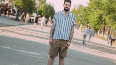 man in striped shirt and shorts on city street