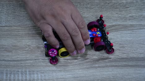 checking the wheels of a tamiya mini sports car by dropping it on a table inside a shop in bangkok, thailand