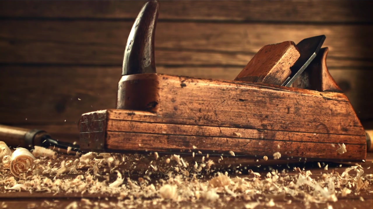 Old Wooden Hand Plane Placed on Workbench with Wood Shavings