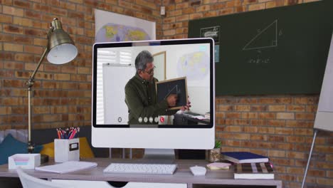 Mixed-race-male-teacher-displayed-on-computer-screen-during-video-call