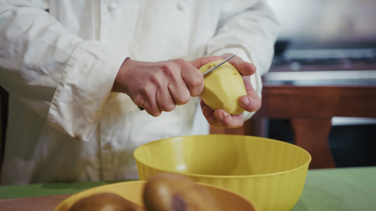 Cocinero pelando patatas