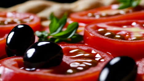 close up of pizza with tomatoes and olives