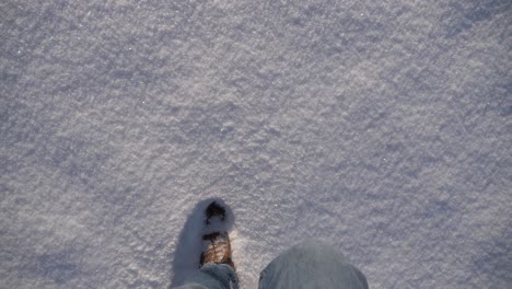 Brown-boots-walking-through-thick-fresh-snow-on-a-sunny-winter-day-in-Bavaria,-Germany