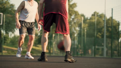 dos jugadores de baloncesto masculinos regateando en una cancha de baloncesto al aire libre 1