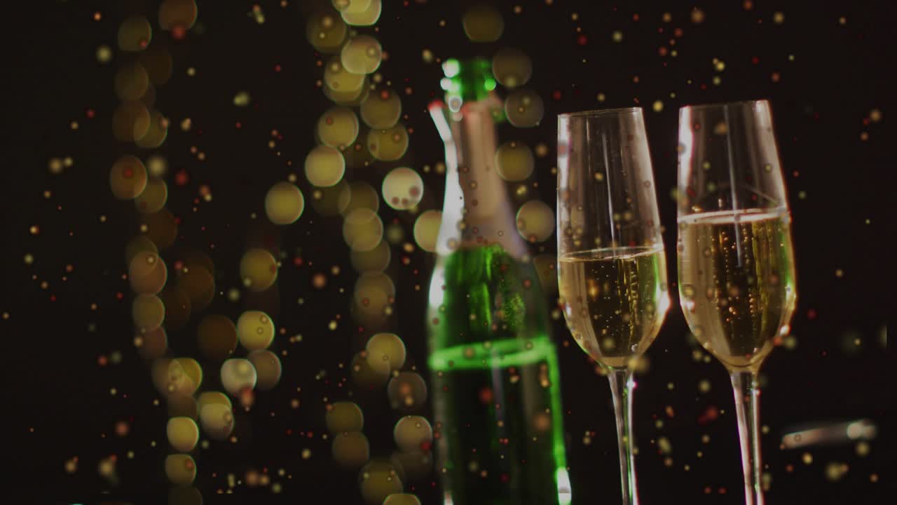 Falling confetti drifting green bottle and two flutes bubbling focus shifting creating cheer