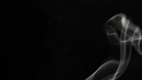 el humo de un cigarrillo que se eleva sobre un negro
