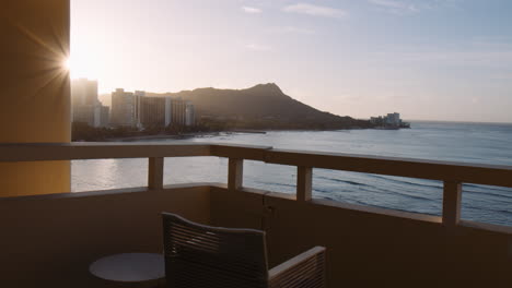 cámara lenta de la bahía de waikiki con bengalas solares y silla vacía en el balcón del hotel, plano general