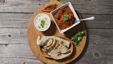 video of tortillas, sauce and seasonings lying on board on wooden surface