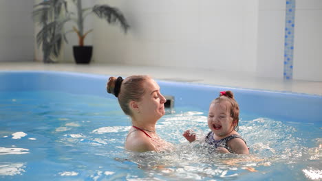 healthy family mother teaching baby swimming pool