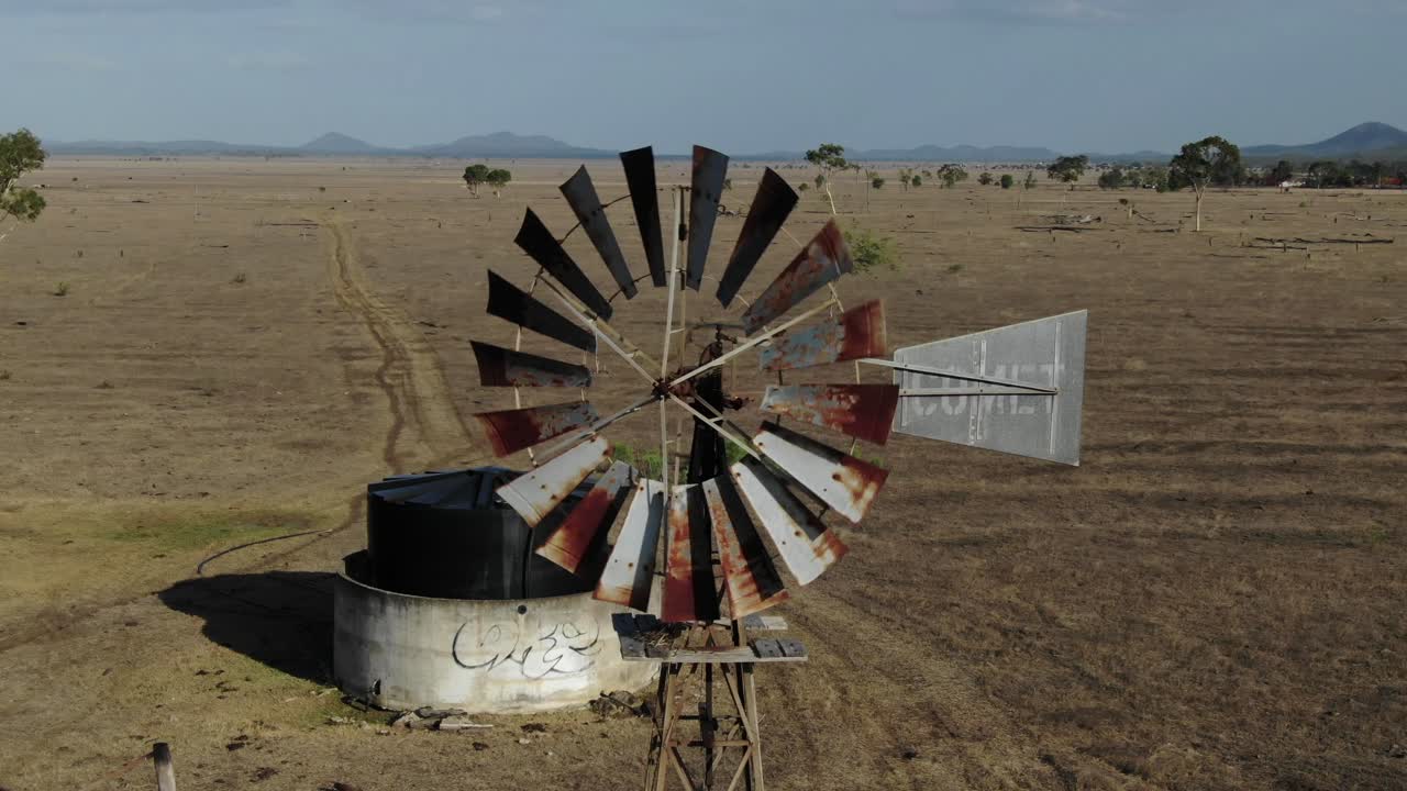 antena en órbita alrededor del icónico antiguo molino de viento oxidado con cuchillas de giro rápido, campo de san lorenzo