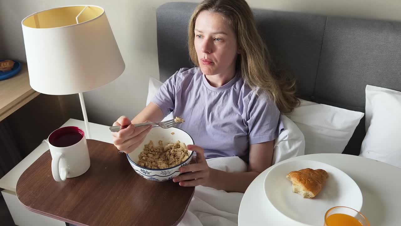 침대에서 아침을 먹는 여자