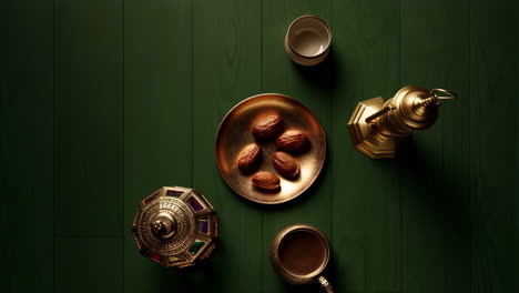 ramadan or eid celebration arrangement with dates, golden lanterns, and cups on a green surface