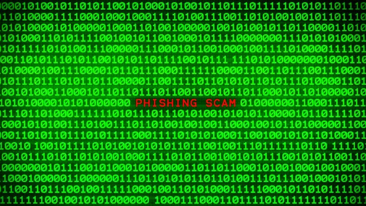 La parola PHISHING SCAM che appare su un muro di codice binario verde tra uno sfondo a matrice di dati binari casuali