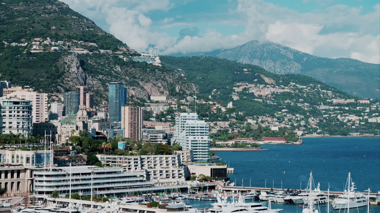 Vista aerea delle barche ormeggiate nel porto turistico di Monaco, con lo skyline della città sullo sfondo