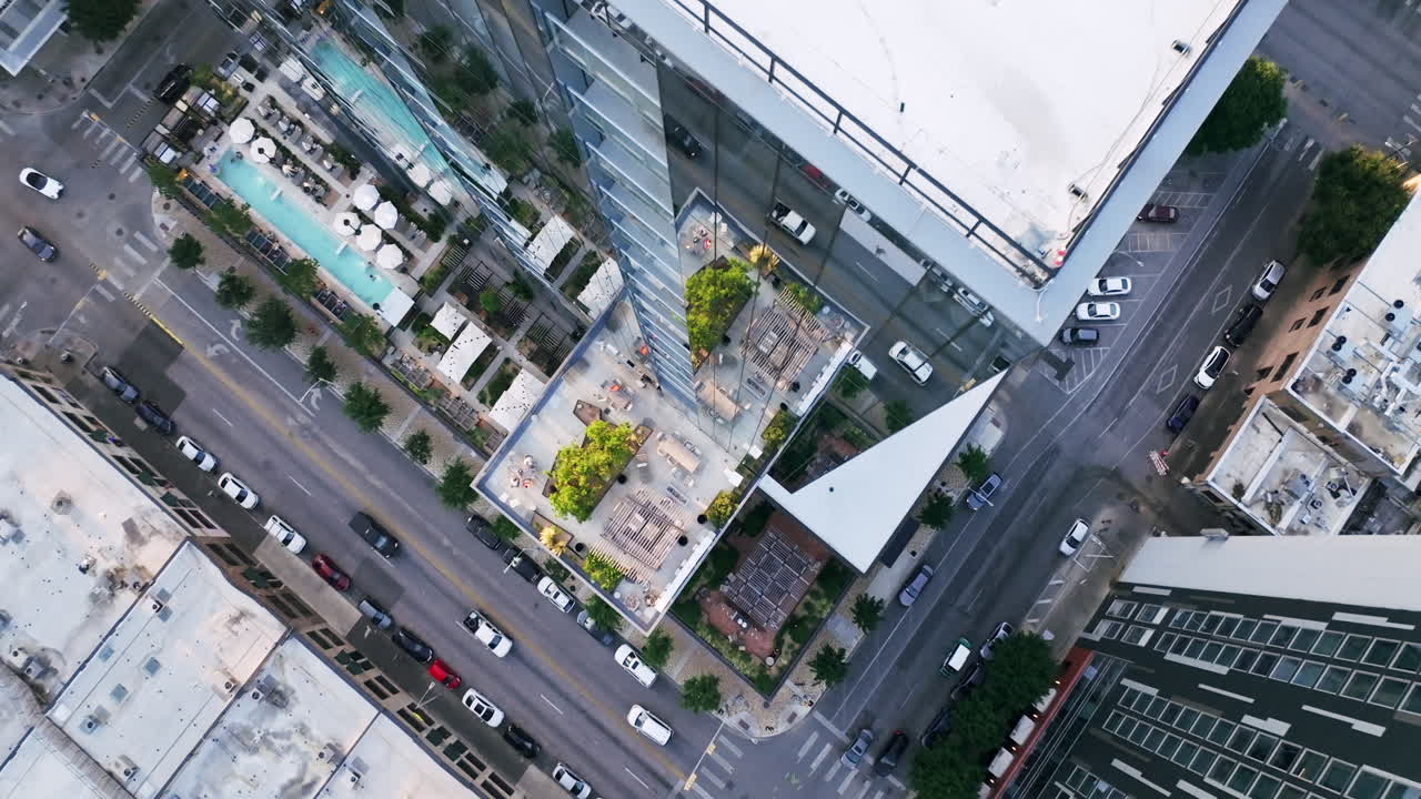 Vista aérea de um edifício urbano moderno com comodidades no terraço e tráfego de rua