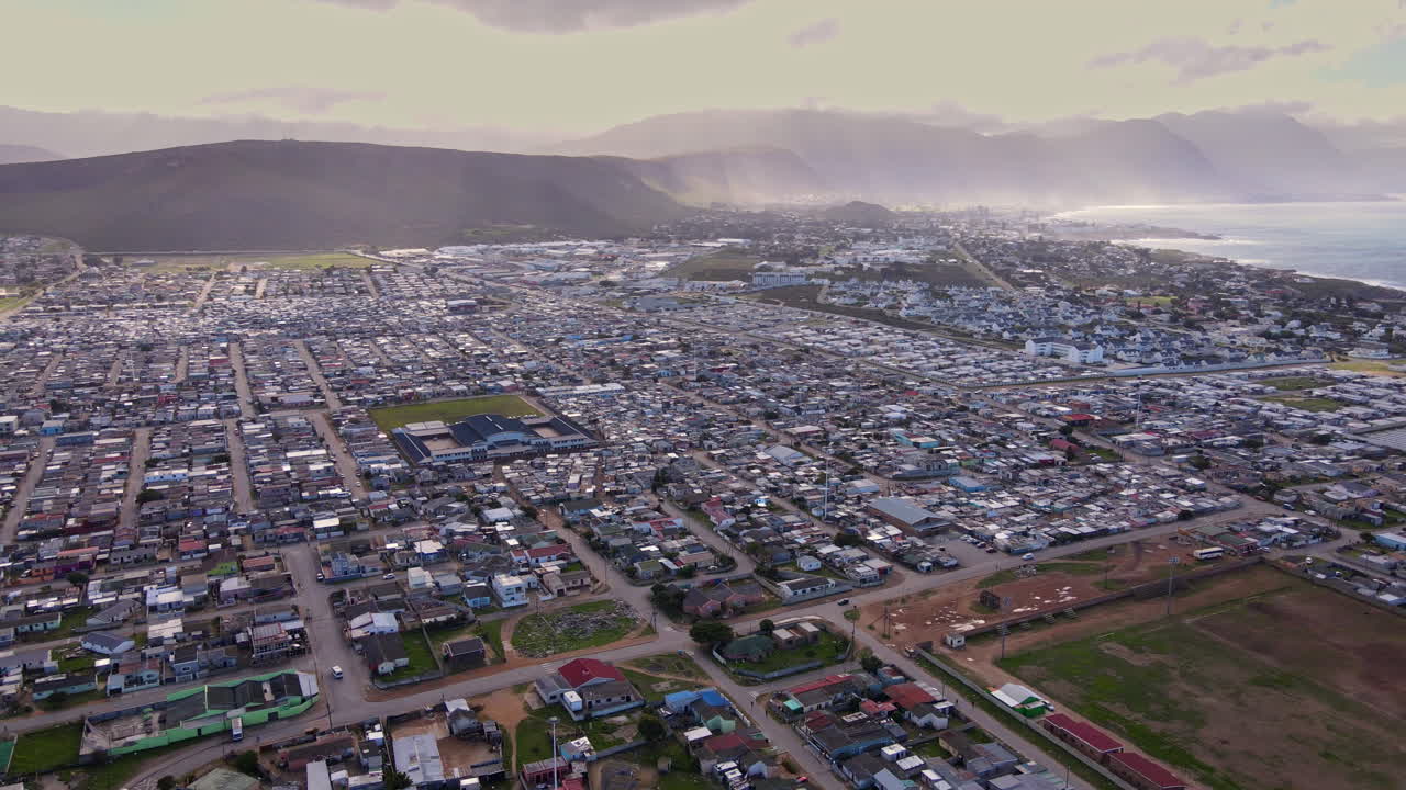 High angle panning drone view over Zwelihle shanty township in seaside Hermanus