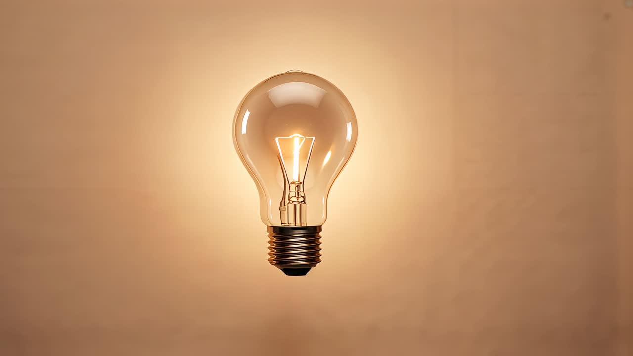 Electric current flowing into incandescent bulb lighting filament to illuminate backdrop in studio