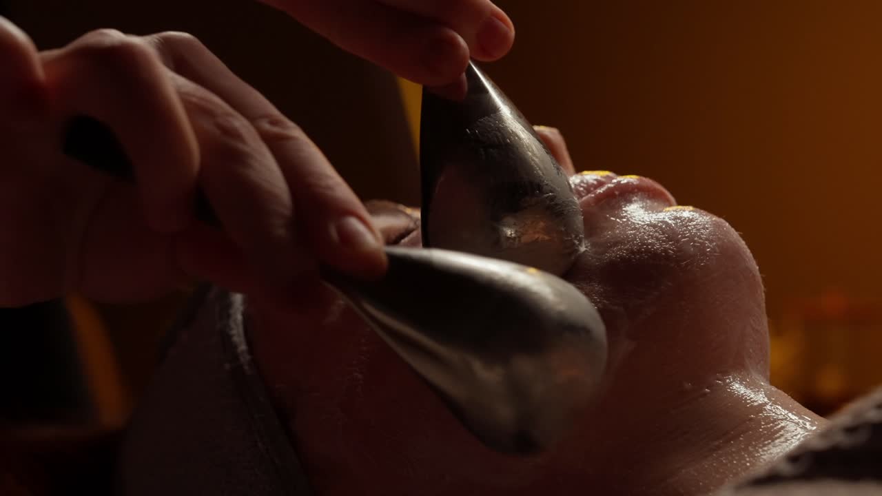 Primo piano di donna che riceve un massaggio facciale con sfere di ghiaccio