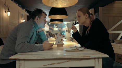 hombre y mujer hablando en un café.