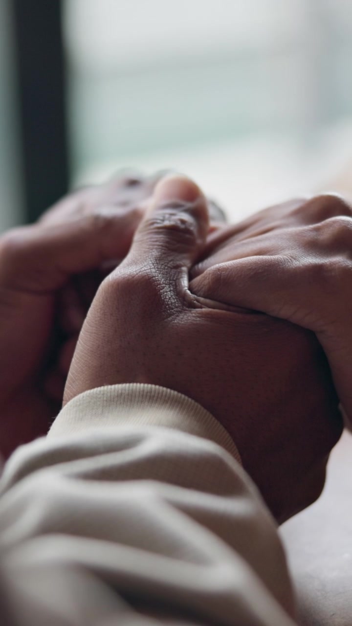 Close-up of Two People Holding Hands in Support