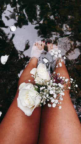 woman's legs with flowers in water