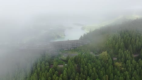 aerial slow pan of ruínas do monte palace hotel with low clouds in são miguel